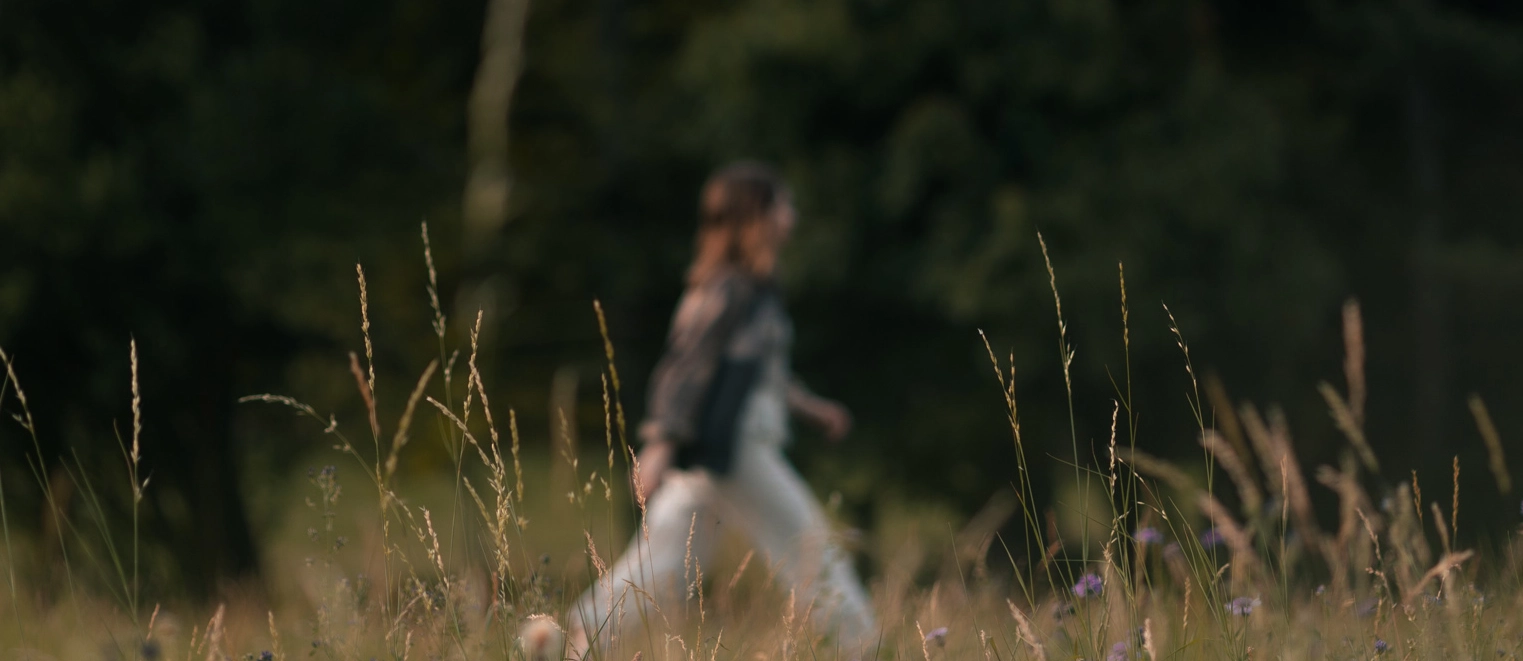 Frau geht auf Wiese, herbstliche Landschaft